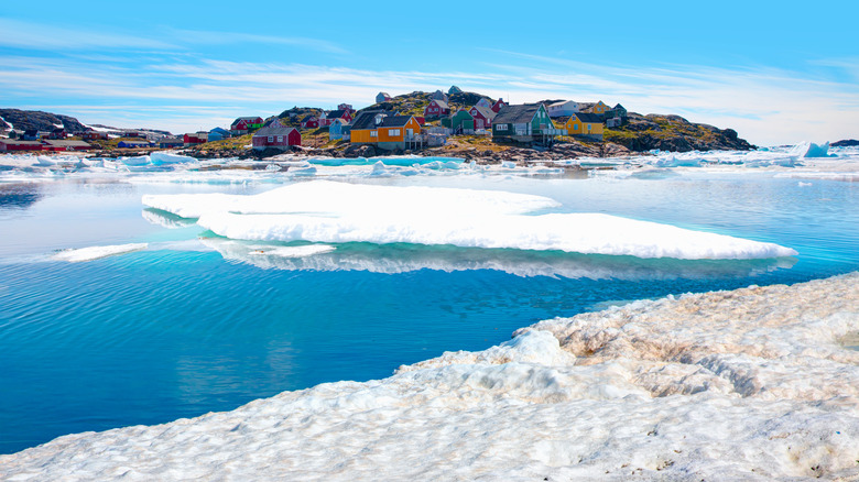 Arctic waters and snow shore in Greenland with village of Kulusuk in background