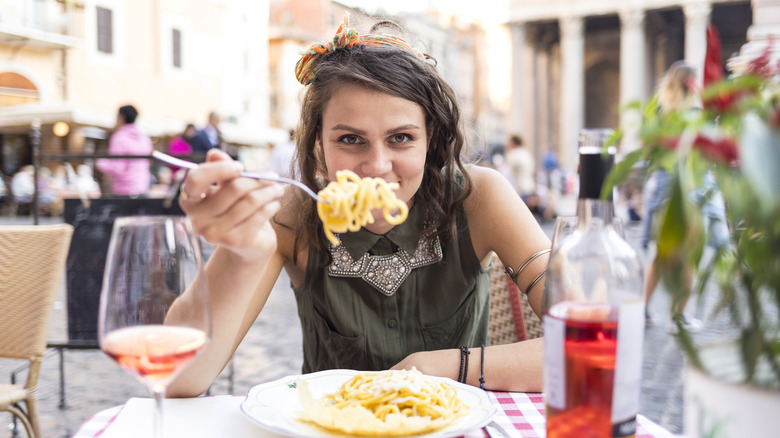 woman eating pasta in italy