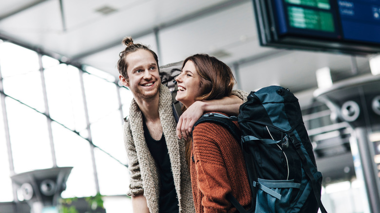 Young couple with backpacking supplies at the airport