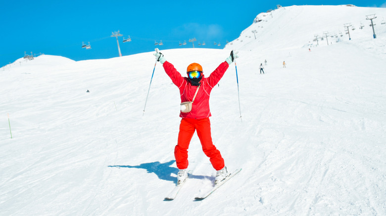 Aline skier with their arms in the air