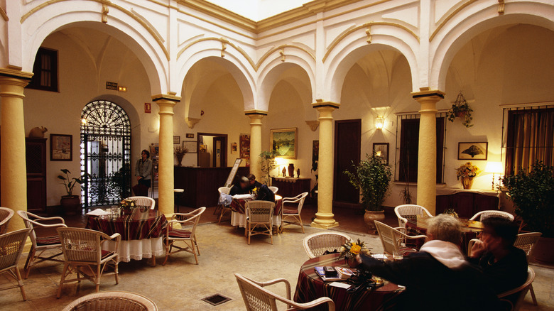 A couple drinks wine and eats tapas inside the arched courtyard in Arcos de la Frontera