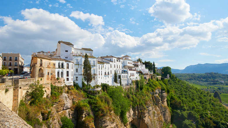 White walls of Spanish village atop cliff with clear blue skies