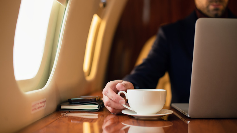 Man with coffee on flight