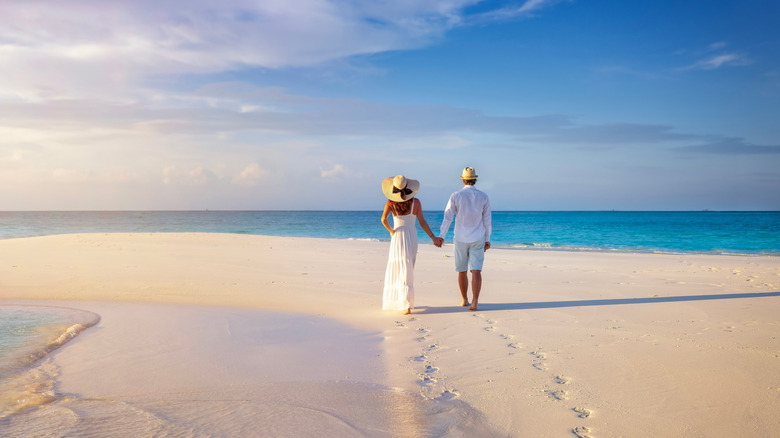 couple holding hands on a beach