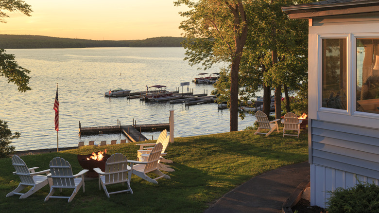 A house and lounge chairs next to water