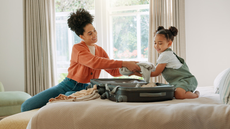 Parent and child pack their suitcase together