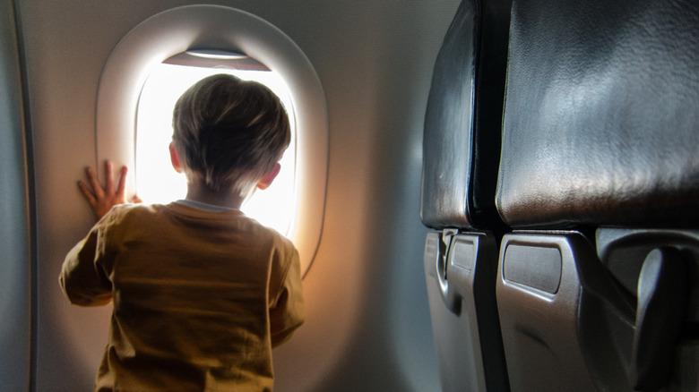 A child looks out an airplane window