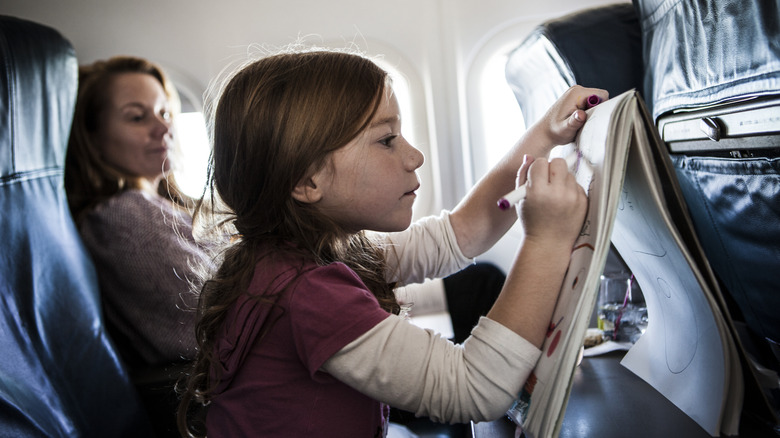 Child drawing on airplane