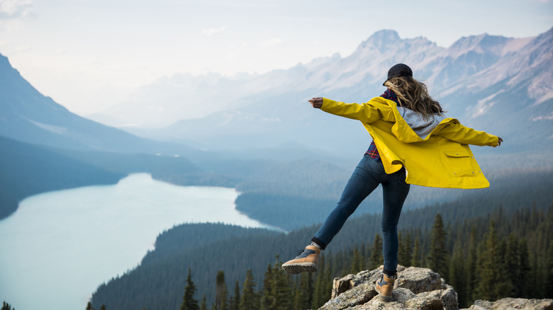 Woman on cliff over lake