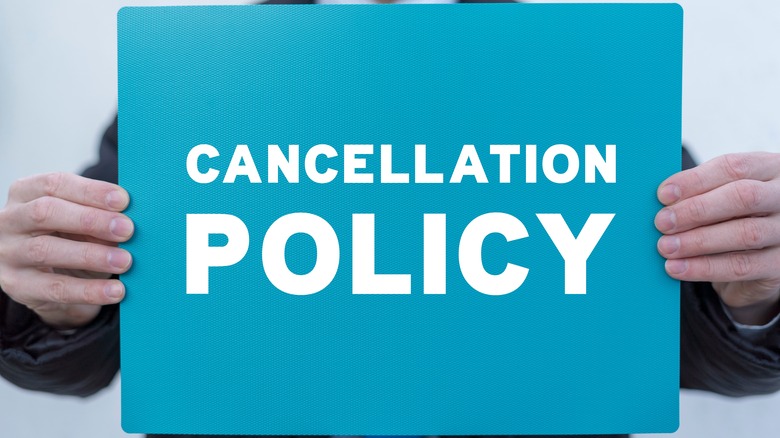 Man with cancellation policy sign