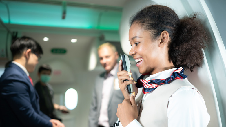 Flight attendant speaking through an intercom