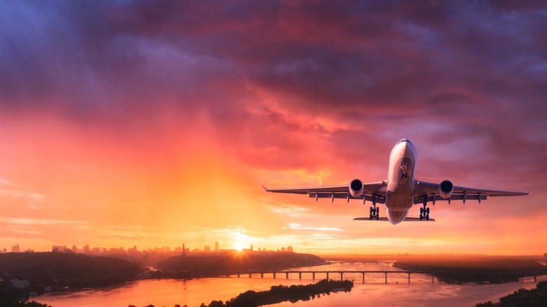 Plane flying at sunset