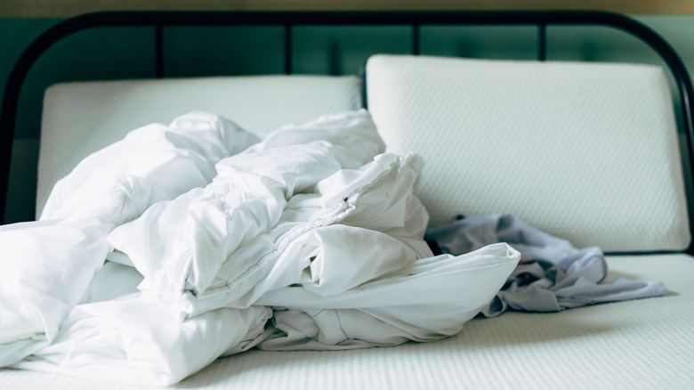 Messy bed sheets on a hotel bed.