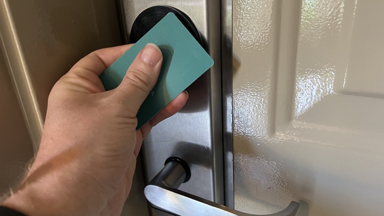 A hotel room door being opened with a key card.