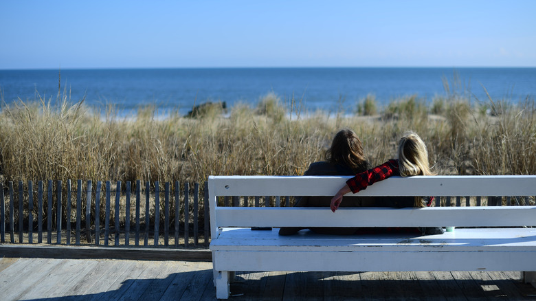 A couple on a bench at the beach