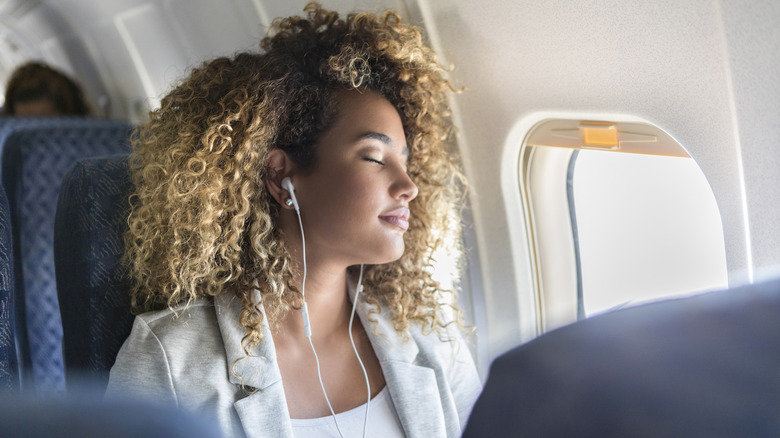 Woman with headphones on plane
