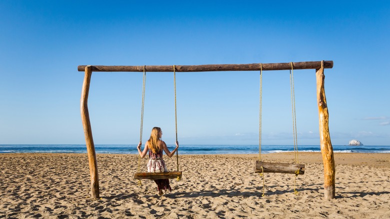 a woman on a swing at Zipolite beach in Mexico