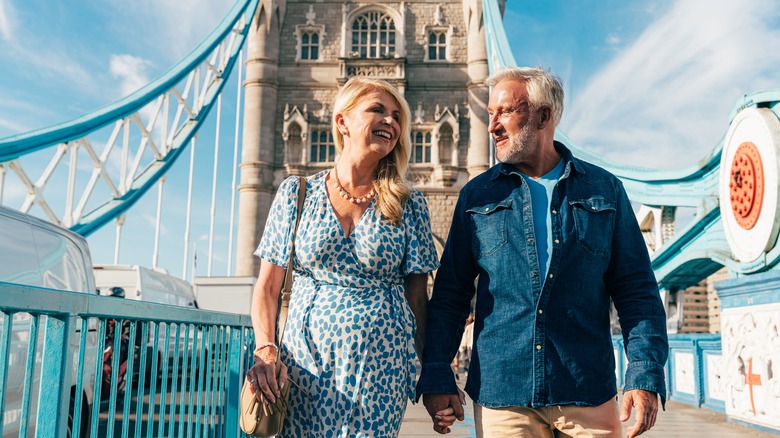 hand-holding couple on bridge