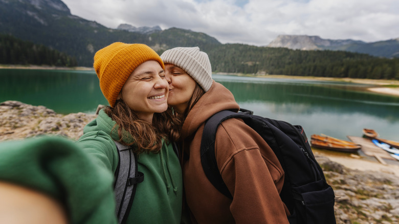 Two women smile and kiss