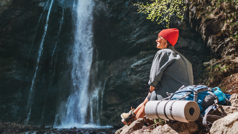Hiker resting near a waterfall