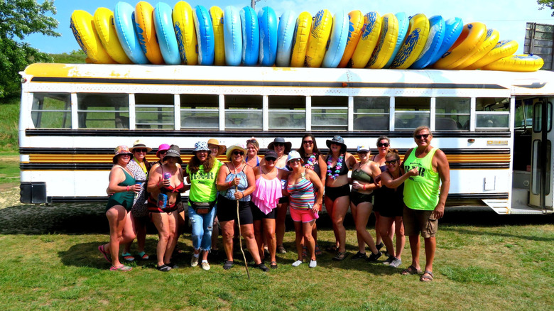 Group standing in front of bus with tubes on top.