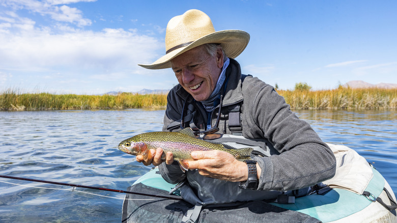 Fisherman holding a trout he just caught