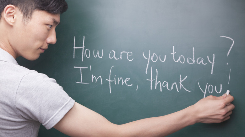 Student writing English on blackboard