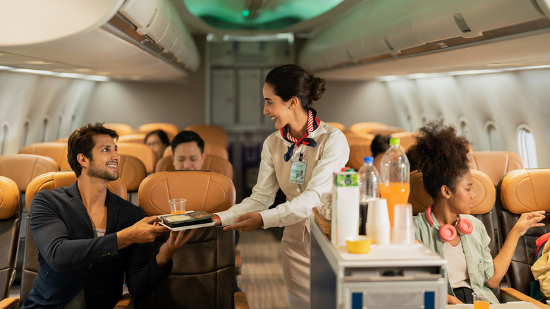 Flight attendant serving passenger