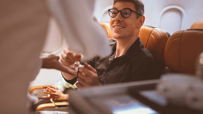 A man receiving service from airplane staff