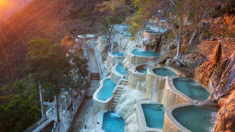 The stone pools of the Grutas de Tolantongo on a forested hillside in Mexico