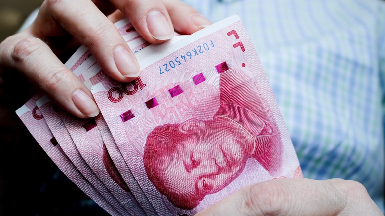 holding stack of chinese bills