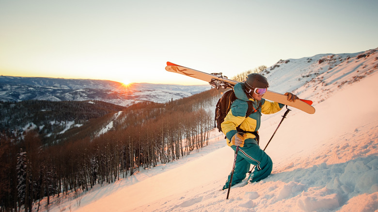 A snowboarder making their way up a mountain to go snowboarding