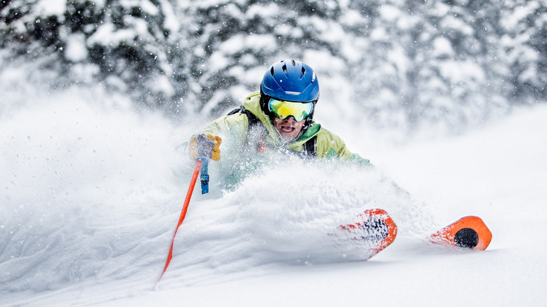 A skier traveling through powdery snow, a highly desirable trait in a ski slope