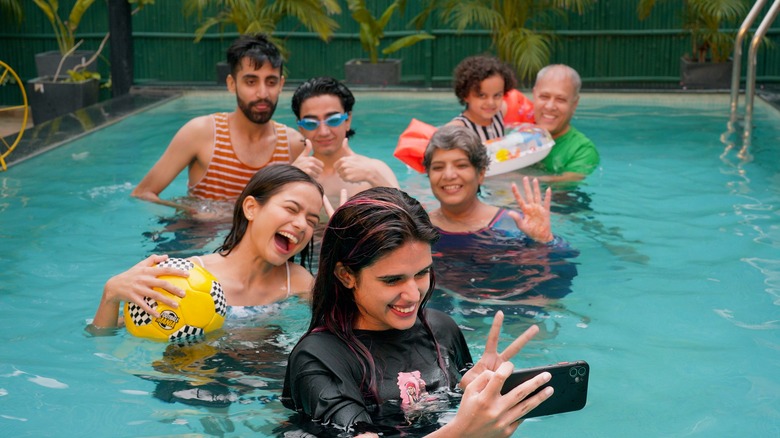 Extended family taking pictures in pool