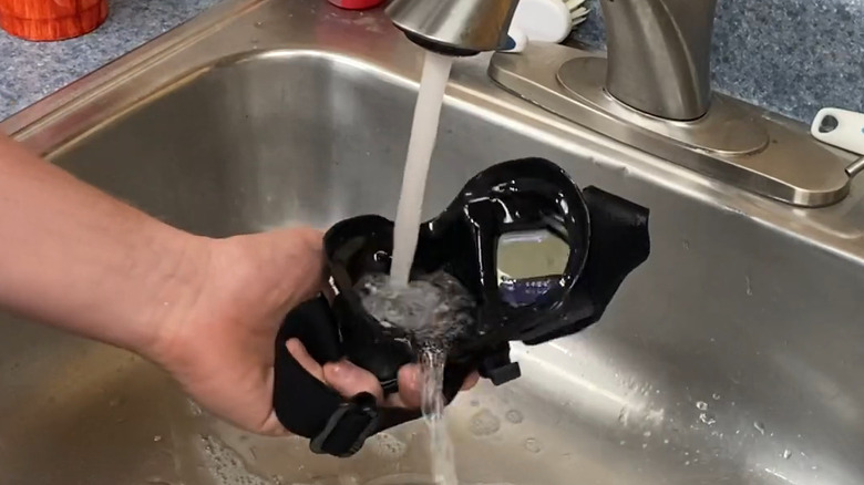 Man cleans scuba mask in sink