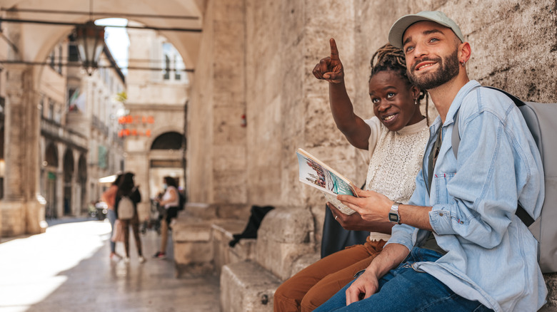 Couple using a guidebook while traveling