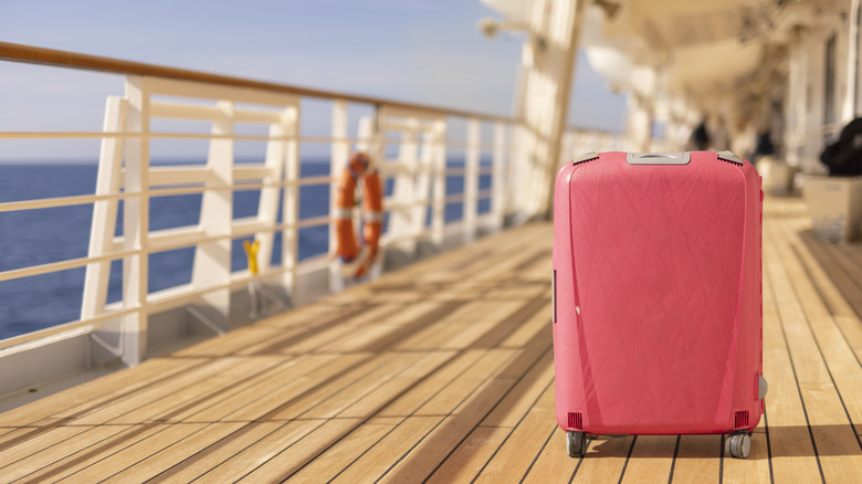 A pink suitcase on a cruise ship deck