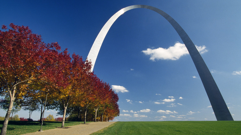 Gateway Arch in St. Louis, Missouri, on a clear day next to trees with red leaves