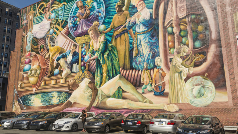 A large mural in Philadelphia in front of a parking lot