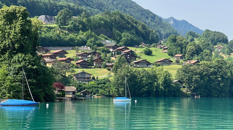 Boats on Lake Lungern surrounded by green mountains with idyllic houses in Lungern, Switzerland