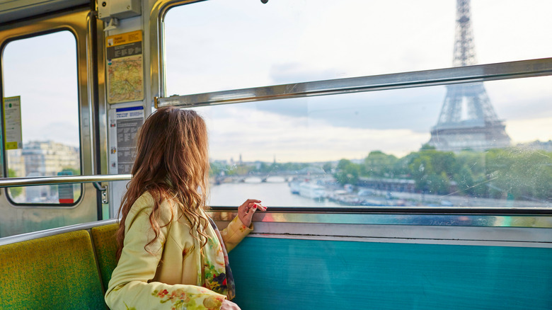 Young woman on train looking at Paris' Eiffel Tower