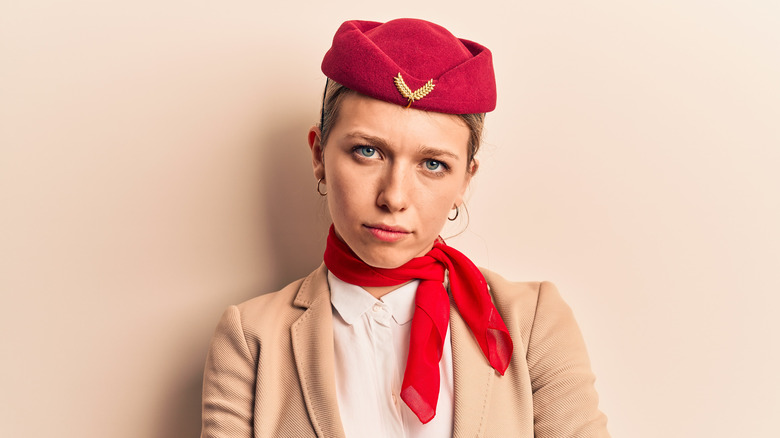 Blond flight attendant with disapproving expression