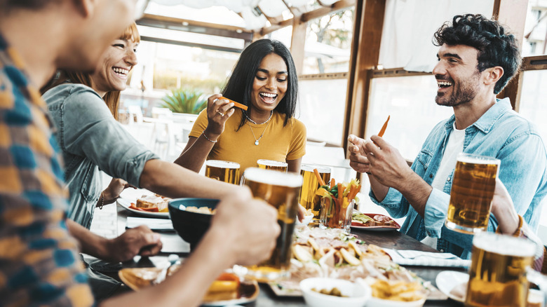 Smiling friends eating at restaurant