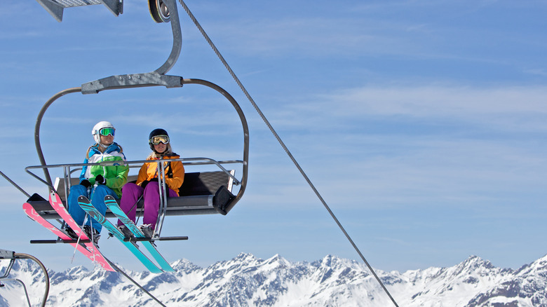 Two people riding a ski lift chair