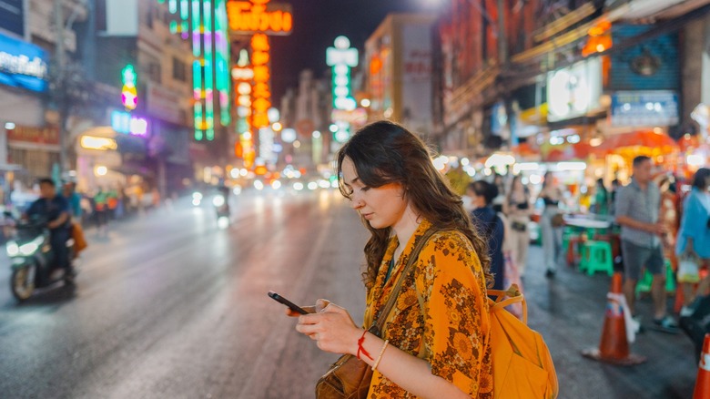 woman walks with phone