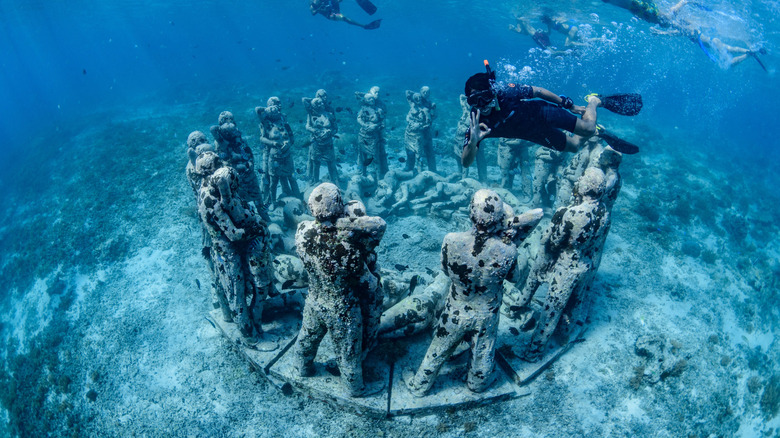 Snorkeler exploring Nest, an underwater statue off Gili Meno in Indonesia