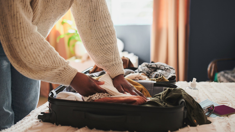 A person packing a suitcase