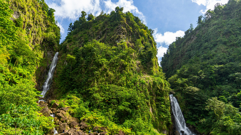 A pair of waterfalls descends from lush, rocky hills at Morne Trois Pitons National Park