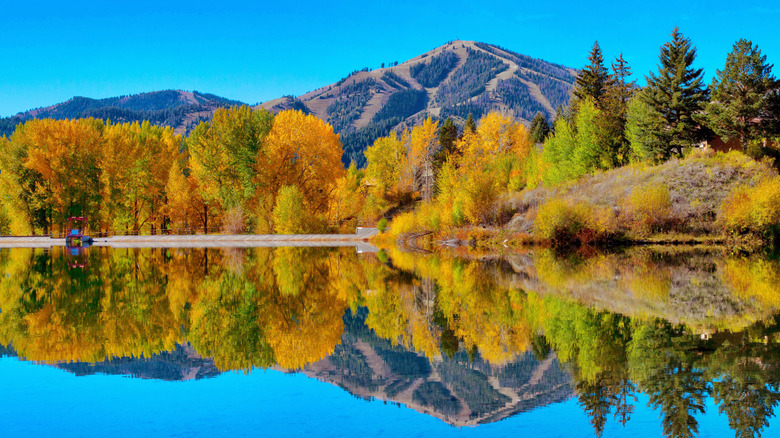 Fall view of Sun Valley with Bald Mountain and trees reflected in lake