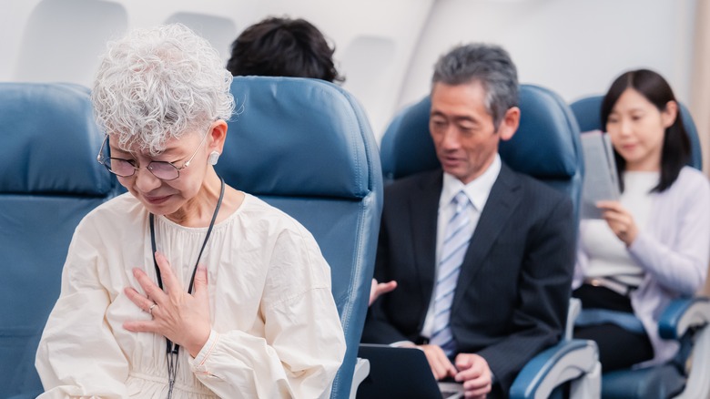 elderly woman feeling sick on flight